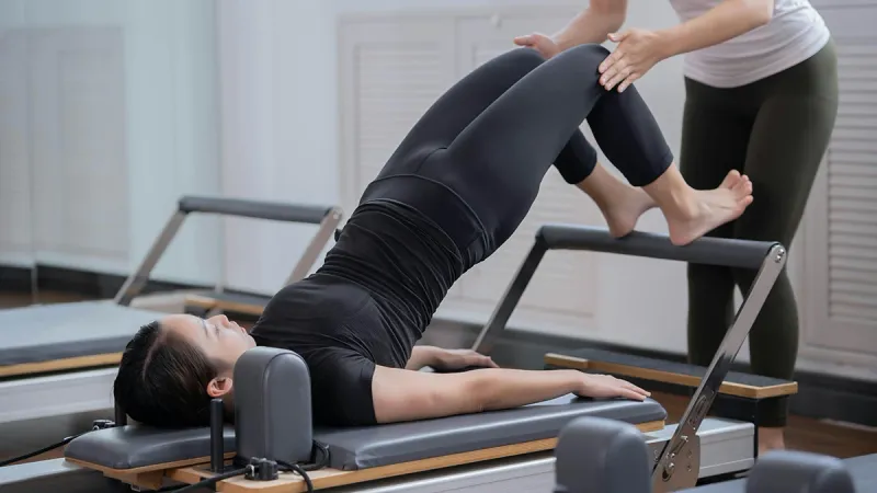 Laura May guiding a pilates client in Dubai